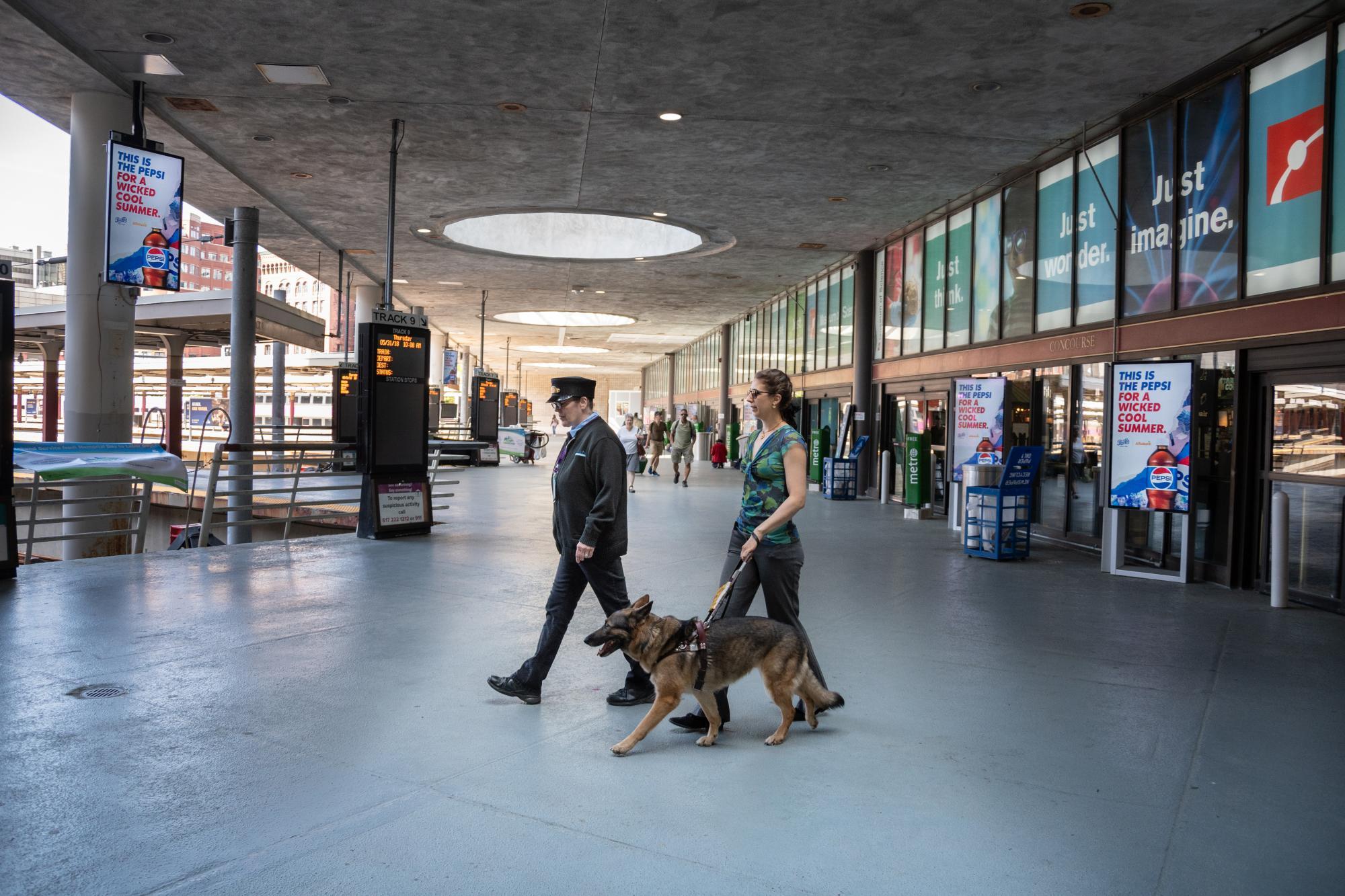 Conductor assisting customer with guide dog