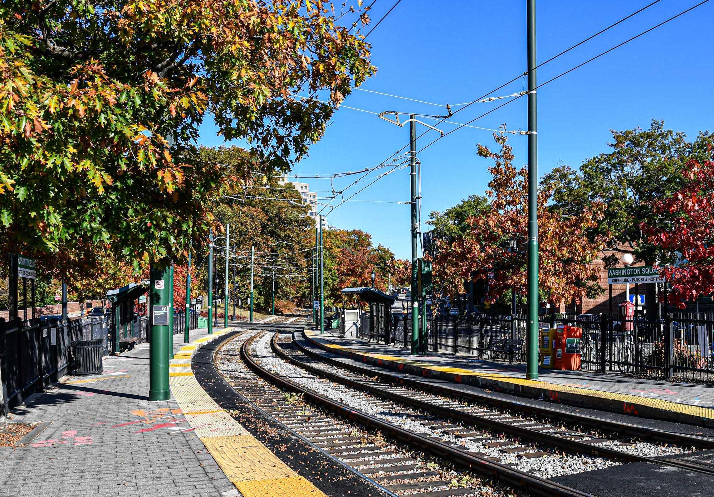 Green Line tracks at Washington Square station surrounded by foliage