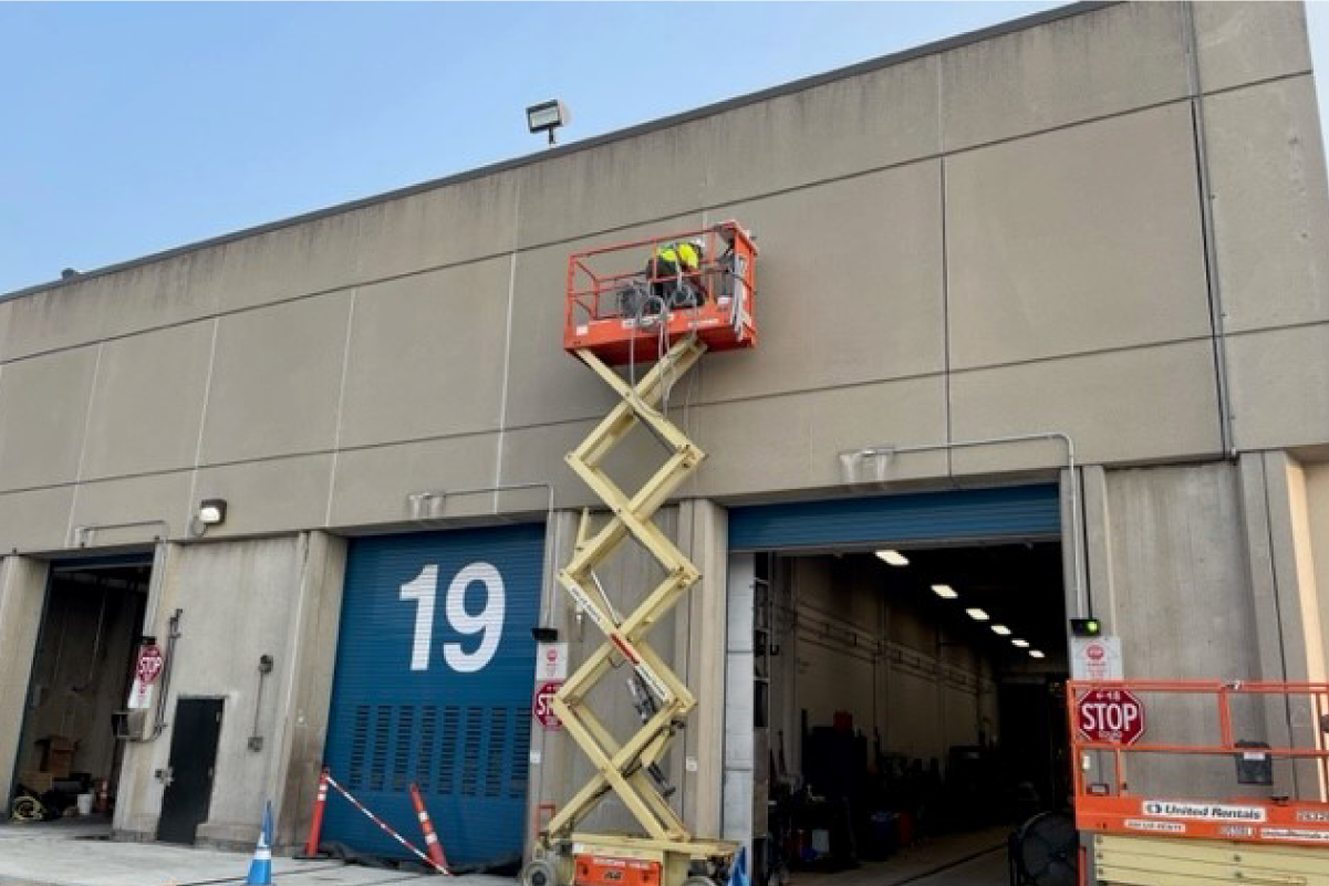 crew member in lift working on outside of a building