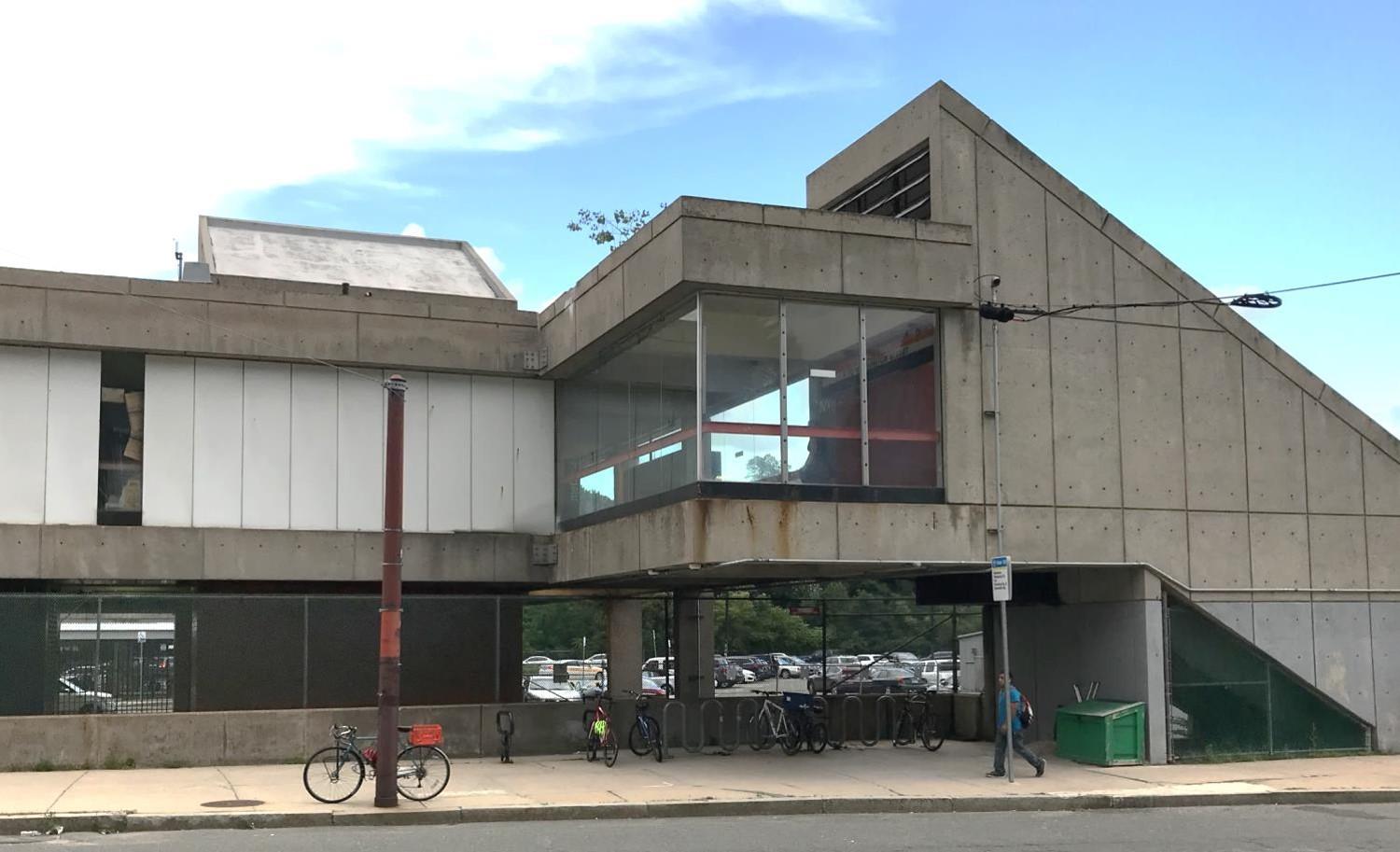 The exterior of Oak Grove Station, centering on the elevated station lobby and the bike racks below it.